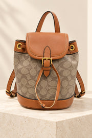 Brown Coach-branded replica monogram mini bucket backpack with caramel trim and gold-tone hardware