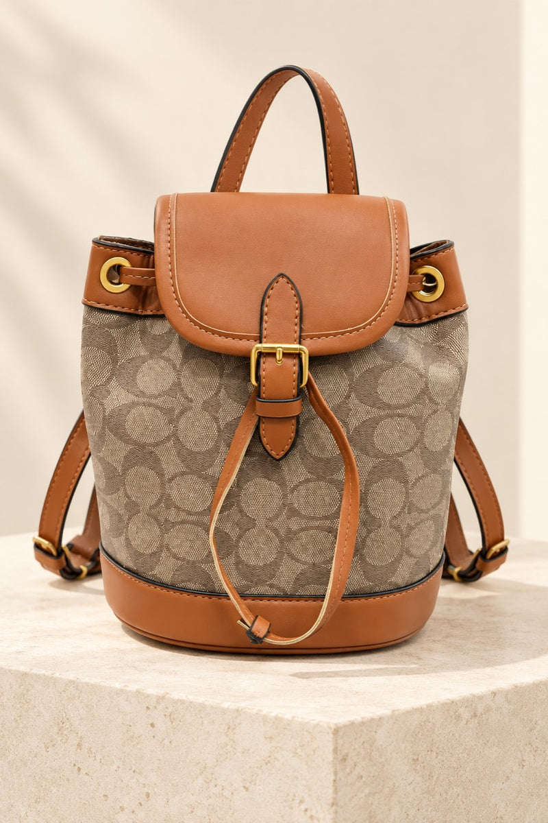 Brown Coach-branded replica monogram mini bucket backpack with caramel trim and gold-tone hardware