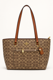 Dark brown Coach-branded replica monogram everyday tote bag with caramel straps and front zip pocket